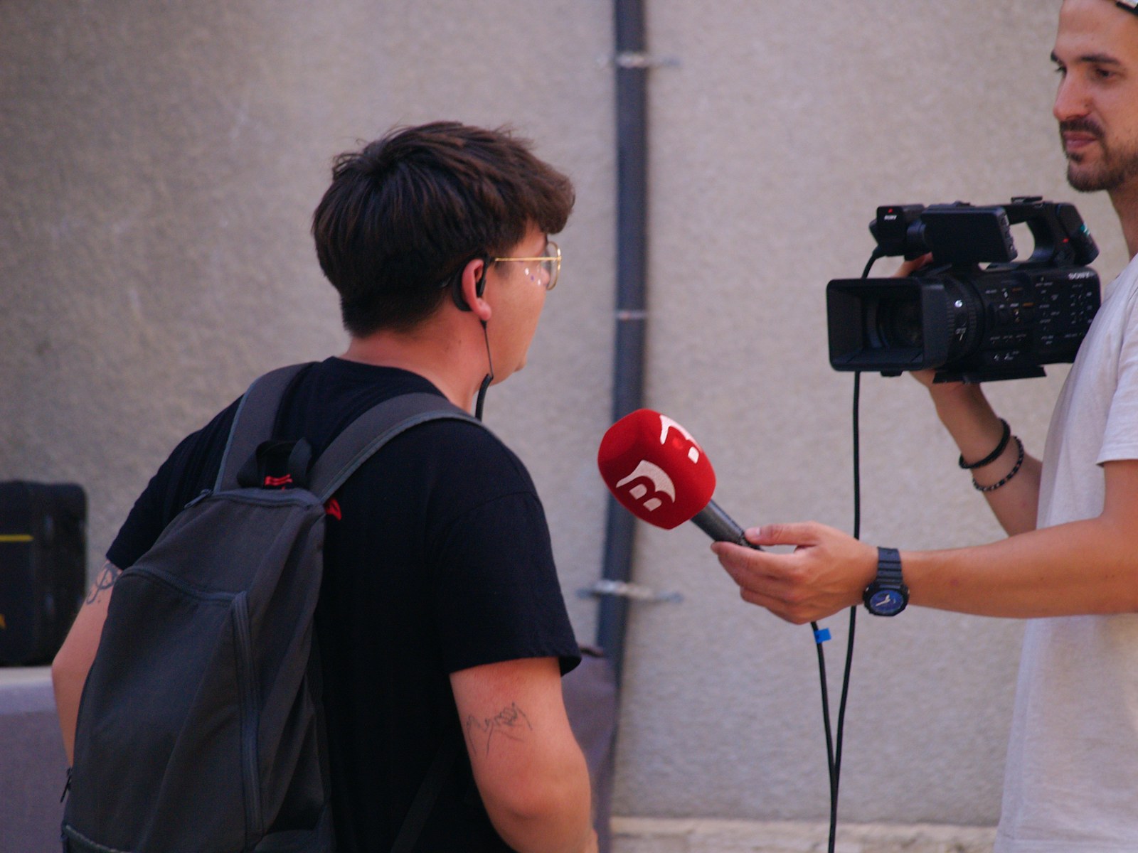 A journalist interviewing a contributor on camera